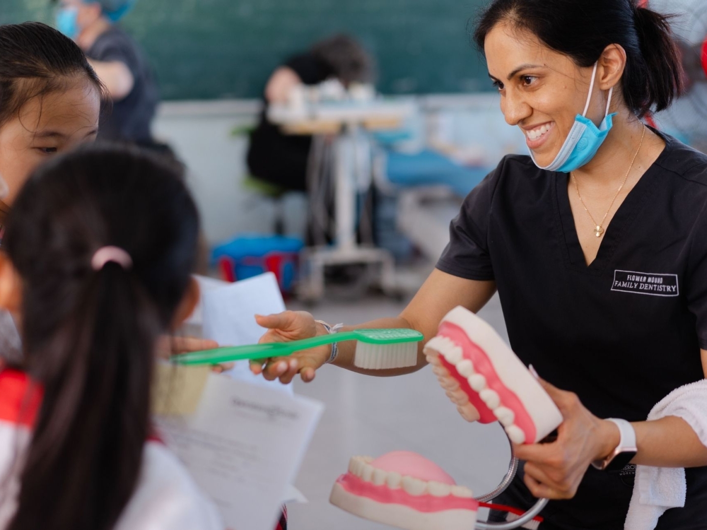 A volunteer shows proper brushing technique during a dental program in Vietnam.