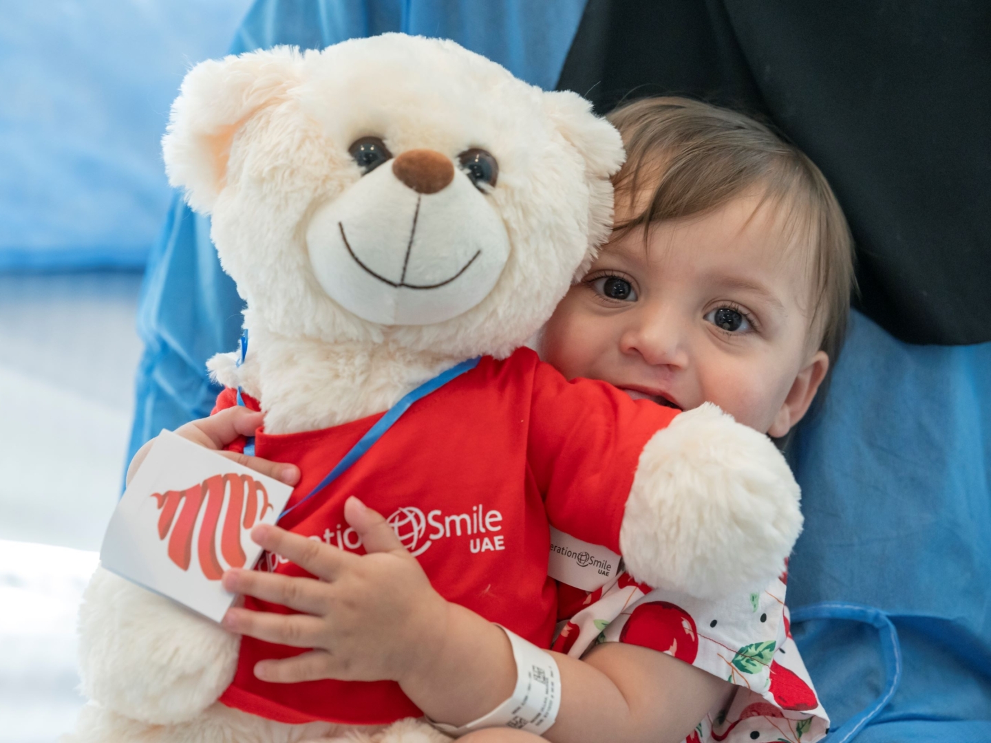 Marwa holds a teddy bear at Operation Smile UAE.
