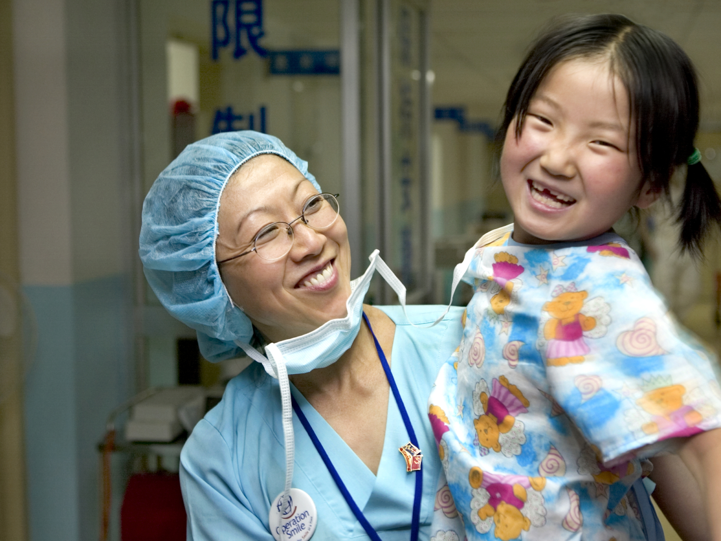 A volunteer and patient smile together during a surgical program in 2005 in China.
