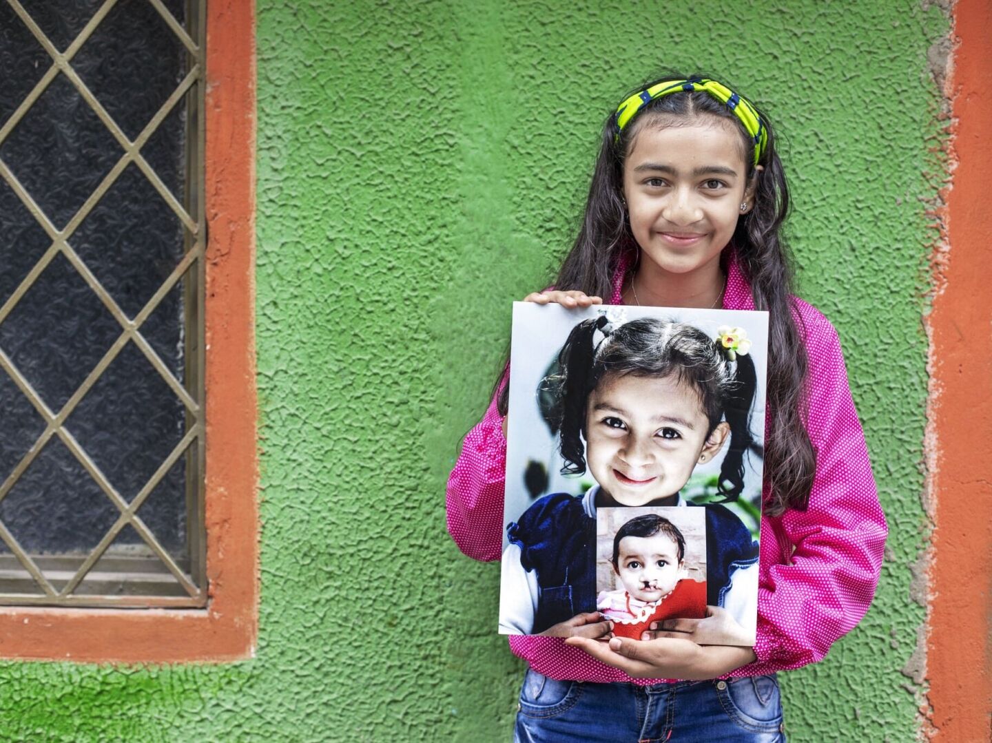 Laura holds both of her before photos.