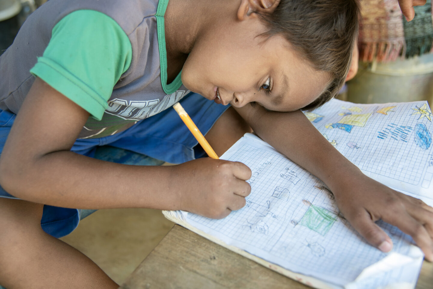 Pedro draws at this family's home in the April Third refugee camp.