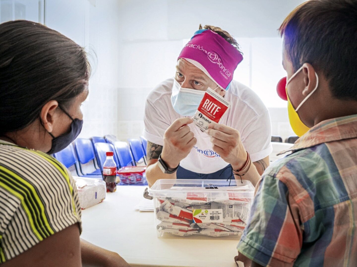 An Operation Smile Colombia volunteer explains the benefits of ready-to-use therapeutic food (RUTF) to a family living in the remote region of La Guajira, Colombia.