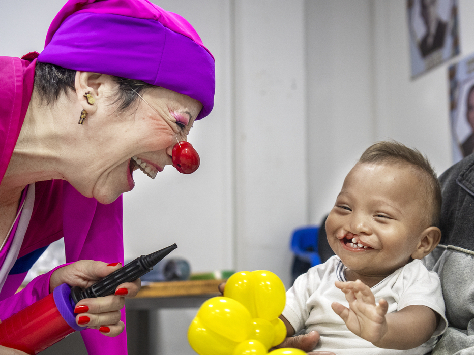 Ihan laughs while playing with a member of Clowns without Borders.