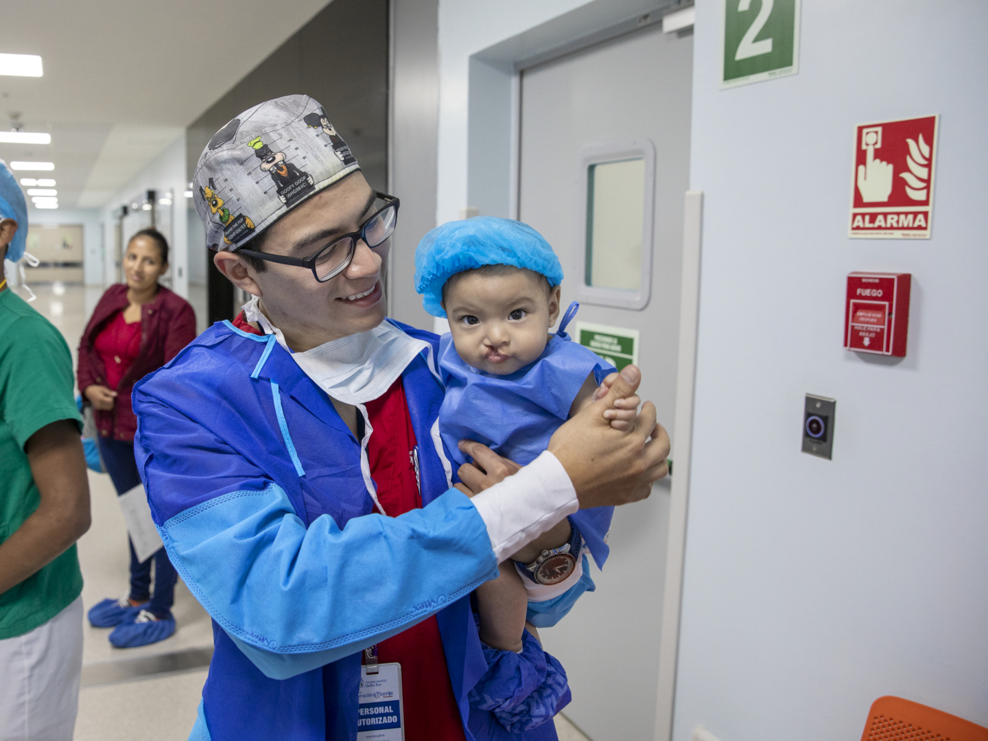 A patient looks at the camera with a volunteer in Operation Smile Ecuador.