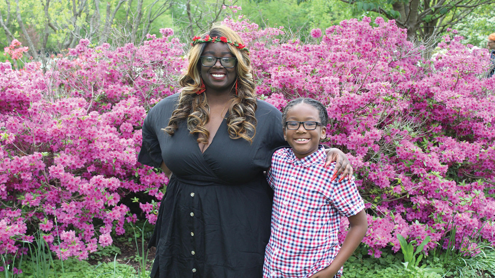 Mother and son standing in front of flowers