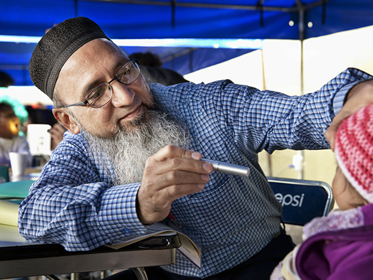 An Operation Smile volunteer examines a patient.