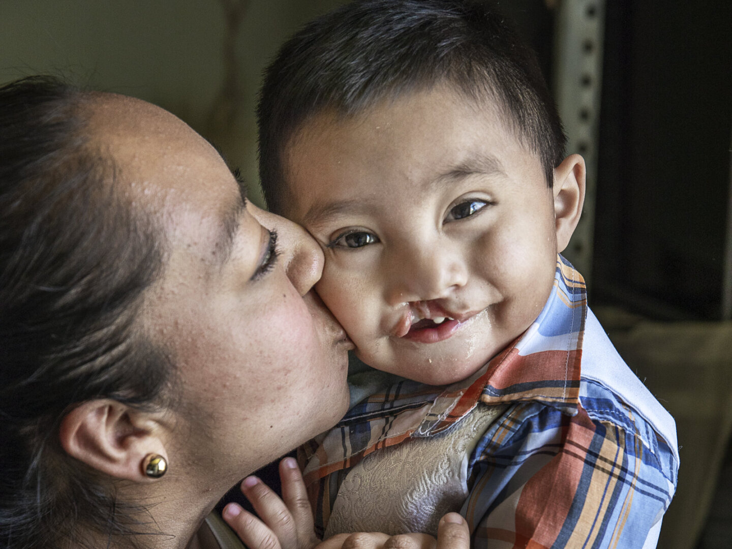 María gives her son, Sebastian, a kiss on the cheek.