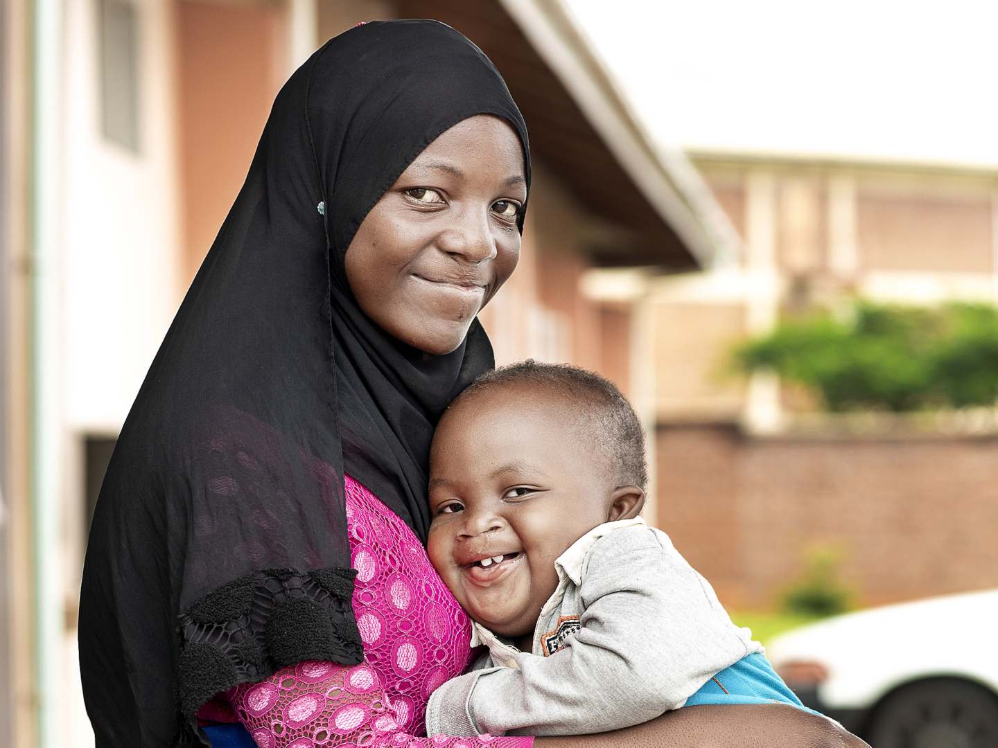 Ashraf smiles wide with his mother months after receiving surgery.