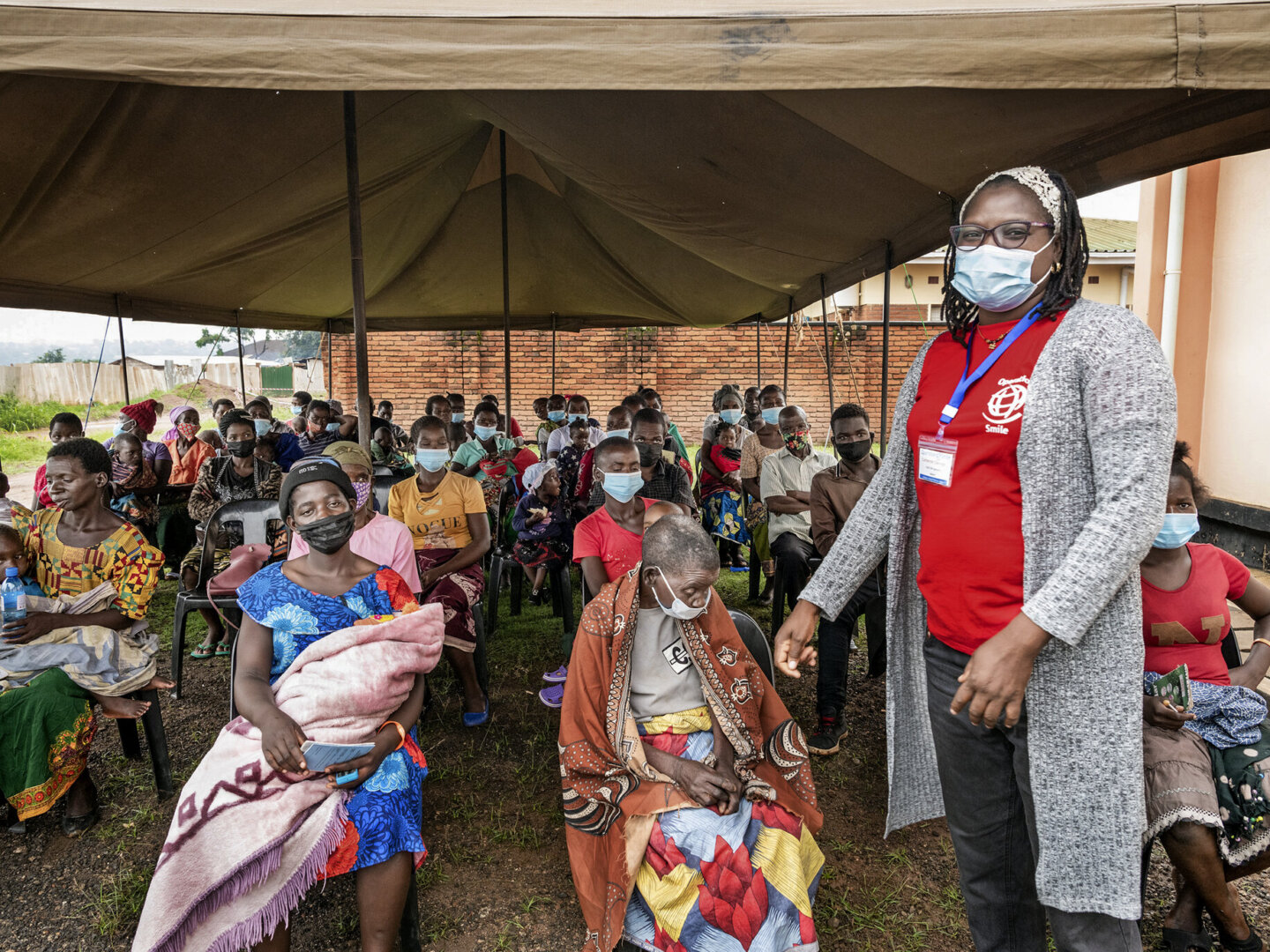 Psychosocial care provider Cathy Cheonga interacts with families of patients at screening during a 2022 Operation Smile Malawi surgical program.