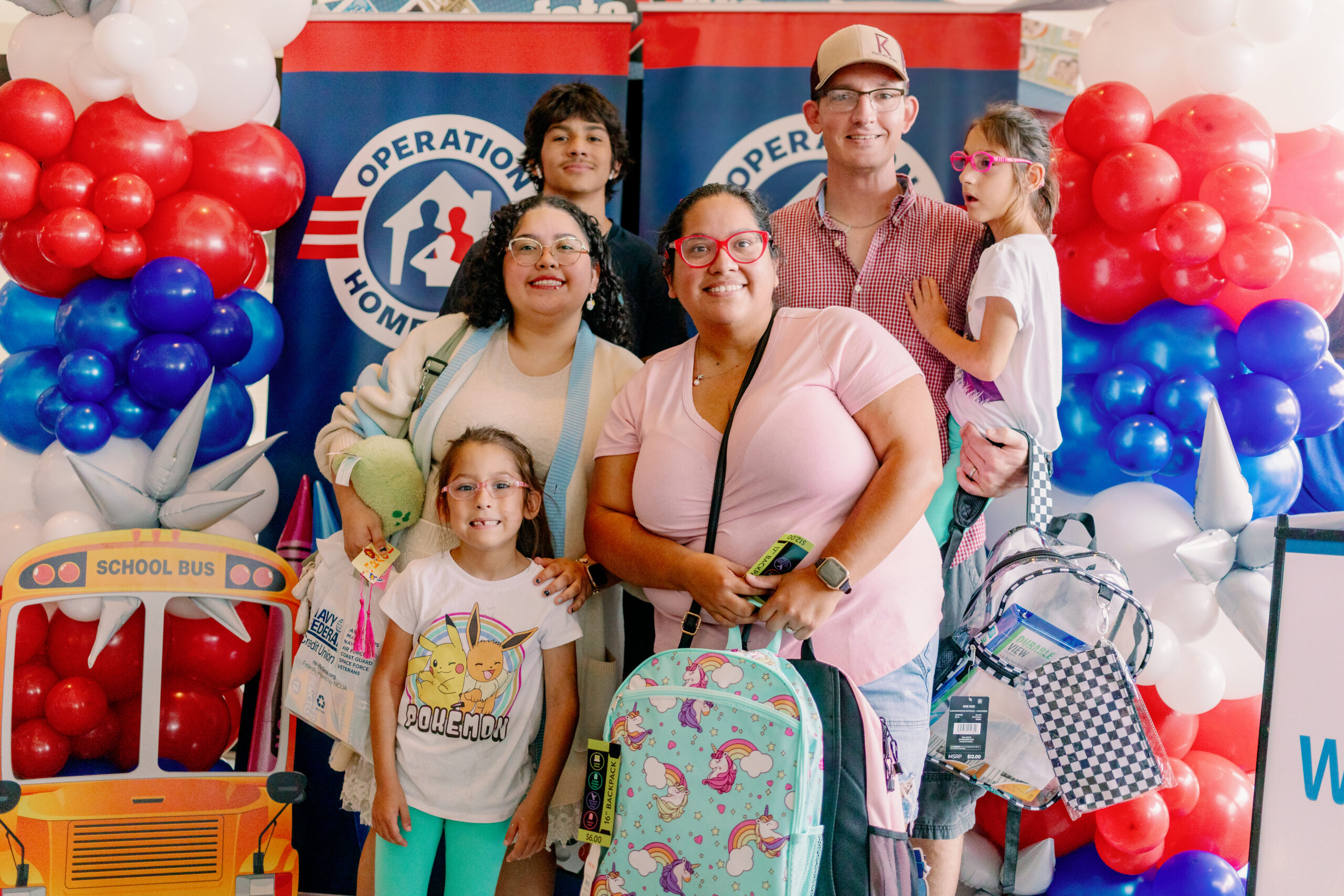 family holding school supplies