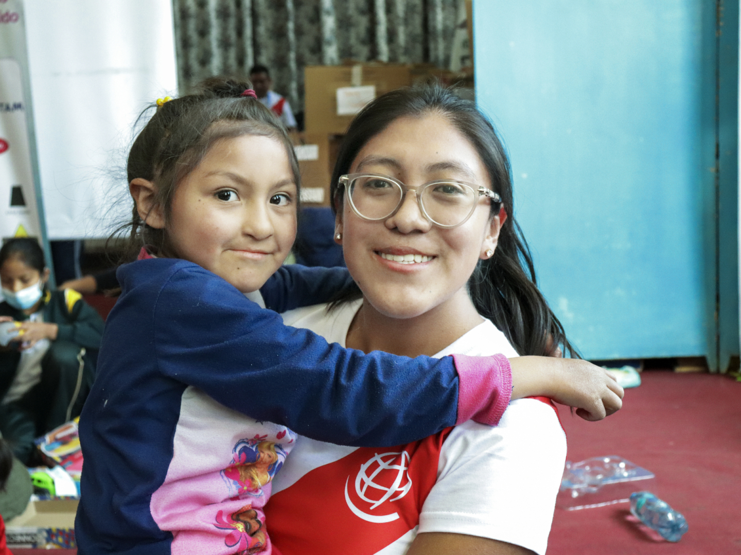 Angeles holds a patient and smiles for the camera during a surgical program in Peru.