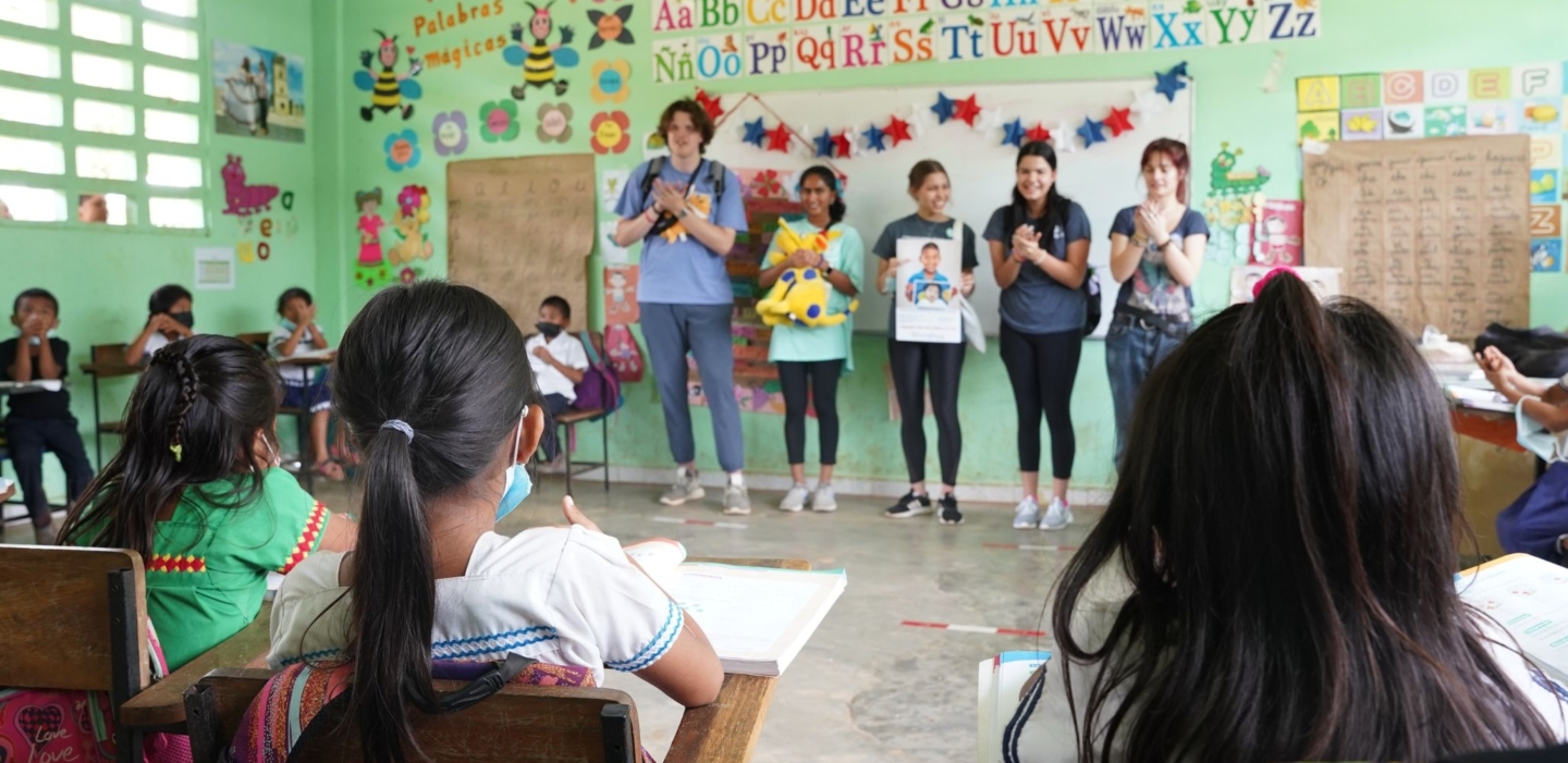 Student Program volunteers speak with children during a surgical program.