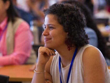 Tereza smiles while listening to a presentation