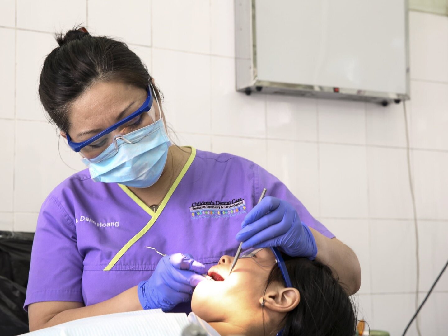 Dr. Dane Hoang provides a patient with oral health care during the 2016 Operation Smile dental program at Hue Odonto-Stomatology Hospital in Hue, Vietnam.
